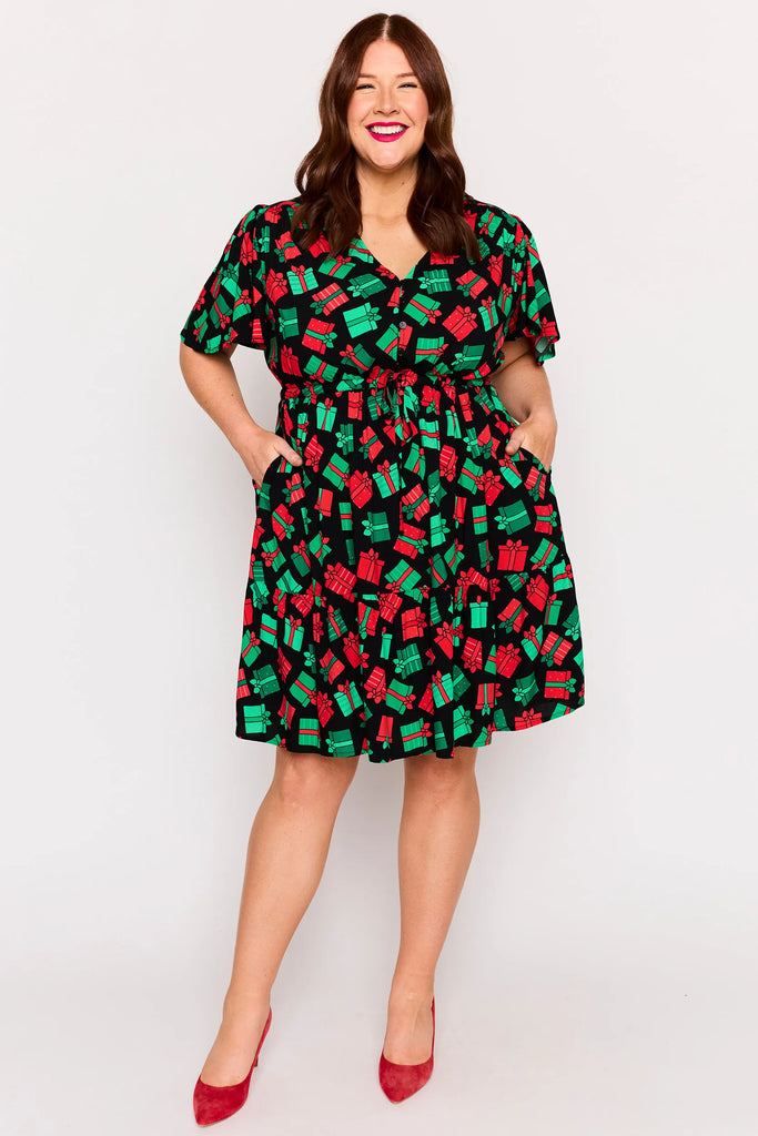 Front View - Pocket detail – Remi dress in Christmas Presents print, white base with red and green gifts