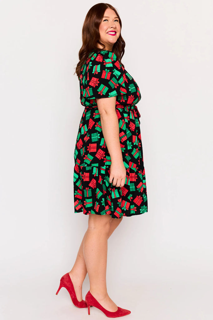 Side view– Remi dress in Christmas Presents print, white base with red and green gifts